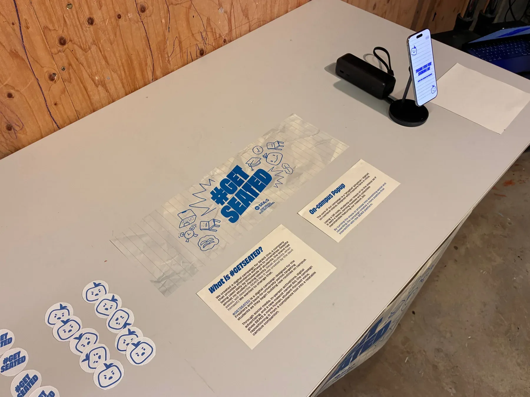 The popup table with campaign cards, check-in instructions and Sophie’s mascot stickers.