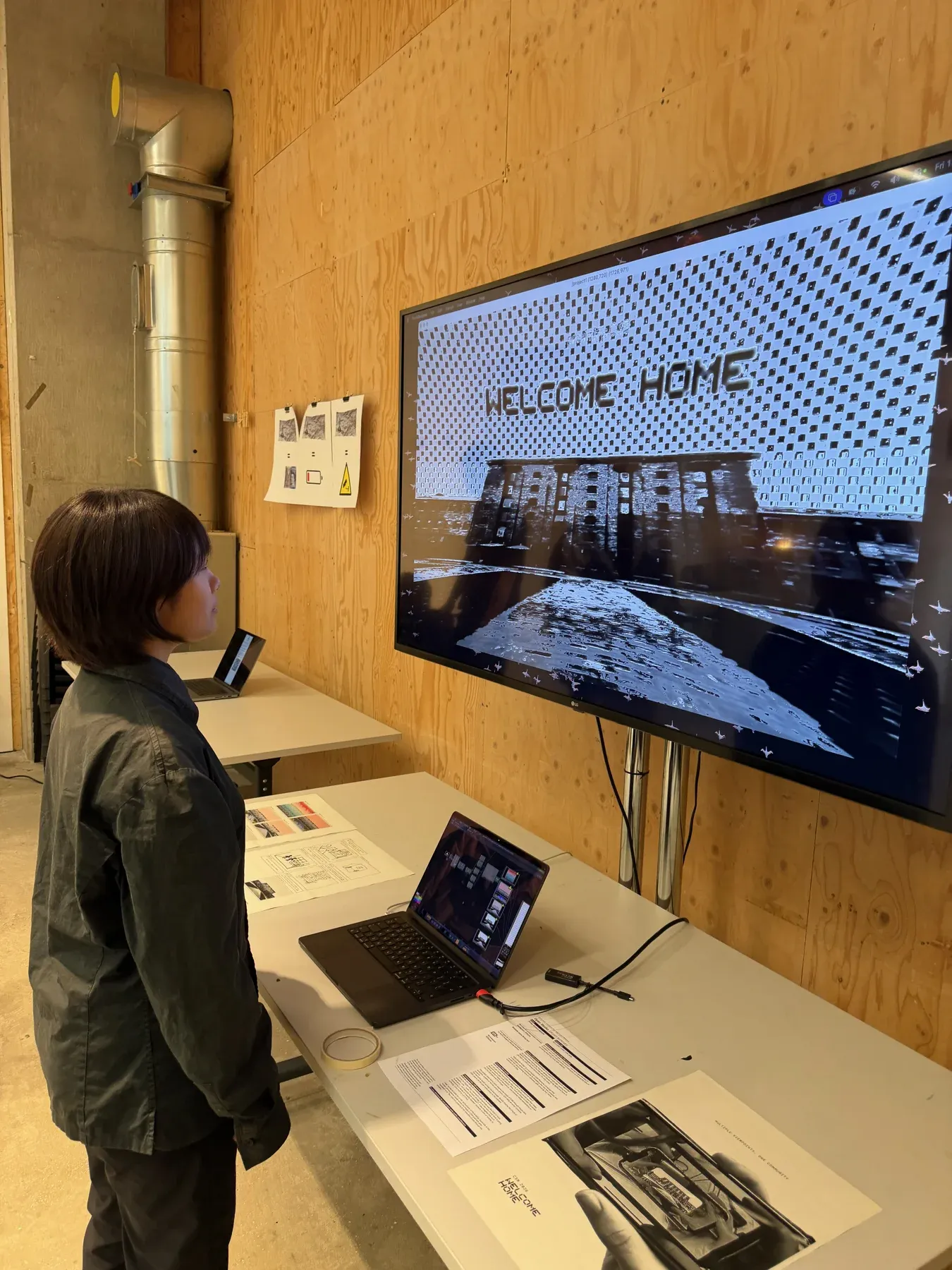 A visitor approaching the installation, revealing WELCOME HOME over the image of CSM.